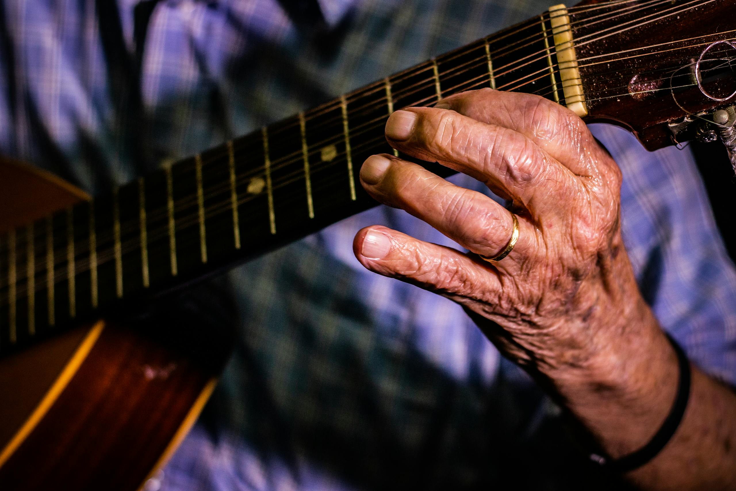 Arthritic elderly hands playing guitar showing joint movement